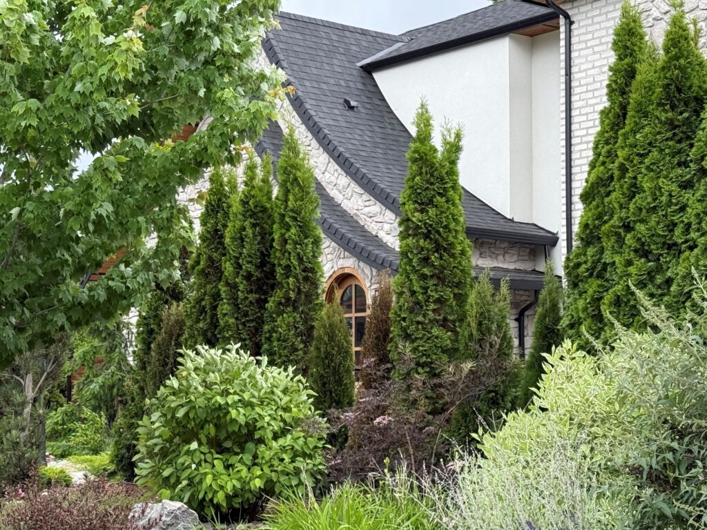 Historic home framed by mature trees and established garden plantings in Kelowna's Heritage Conservation Area
